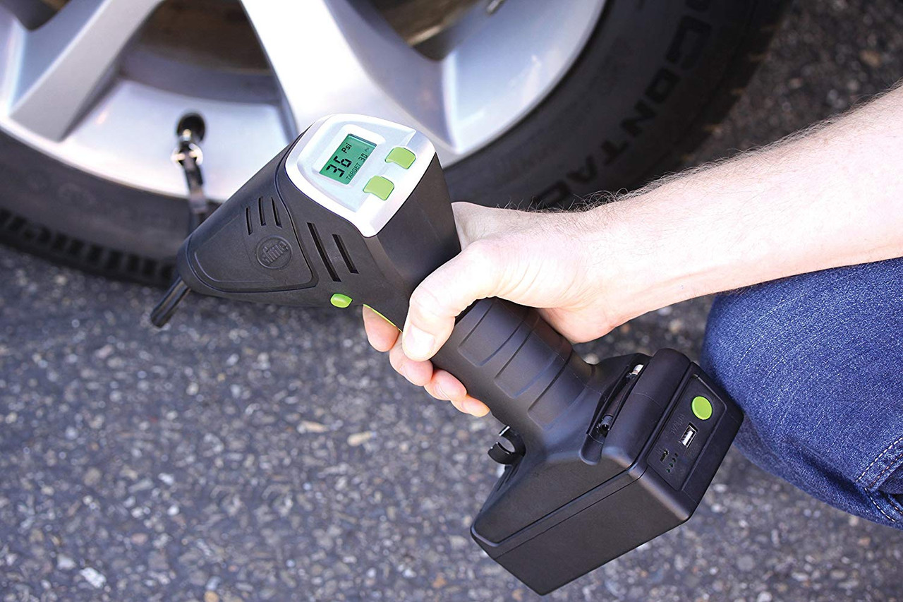 A person using a digital gauge to check tire pressure, displaying 36 PSI.